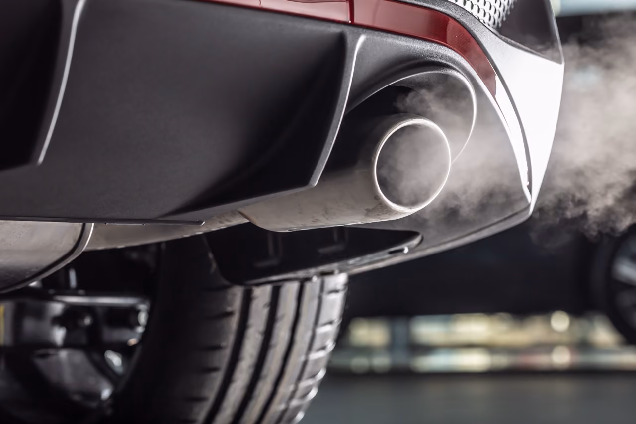 Car exhaust tailpipe releasing smoke, a sign an exhaust repair is needed