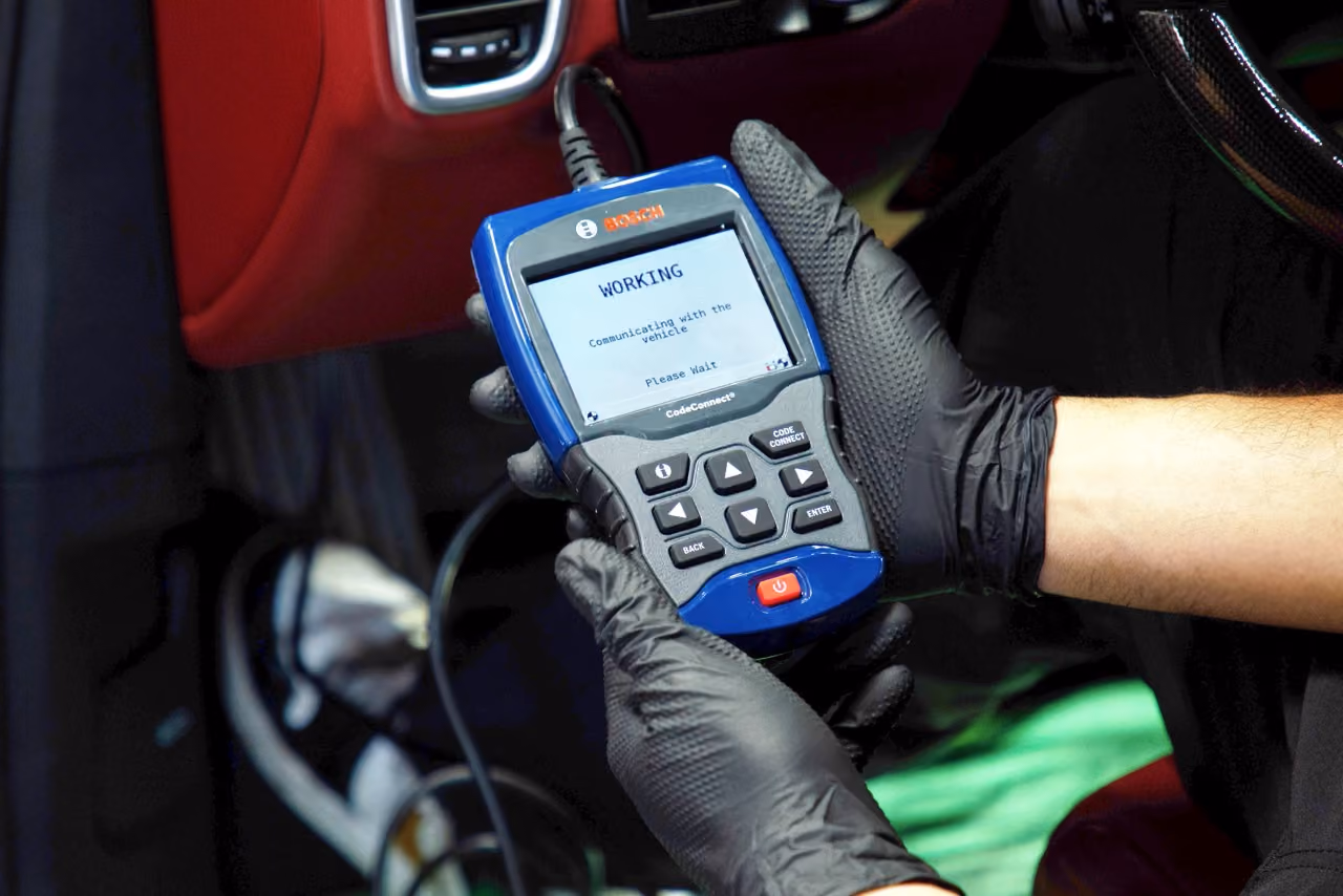 Mechanic reading fault codes with an OBD-2 diagnostic scanner