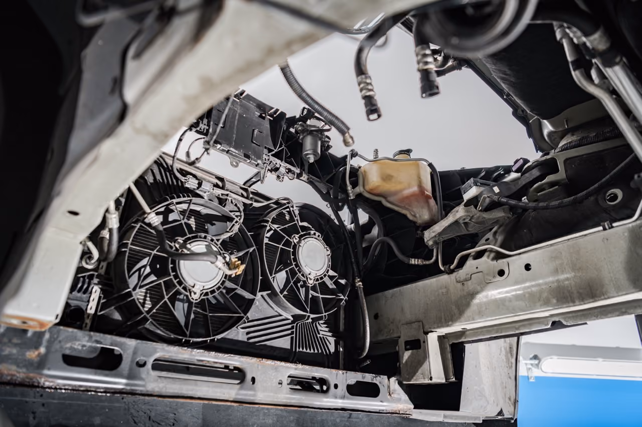 Car radiator fans and cooling system components exposed for a cooling system repair