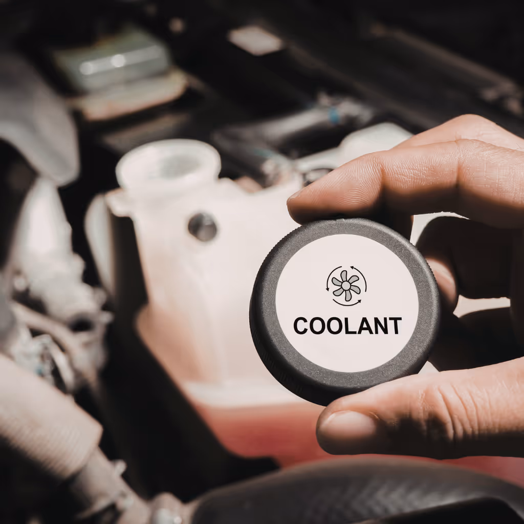 Hand removing a coolant cap during a cooling system check