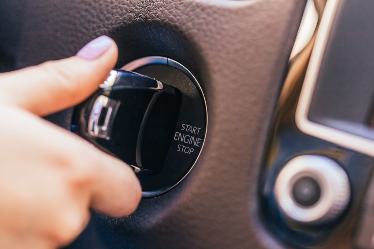 Driver pressing a keyless engine start button
