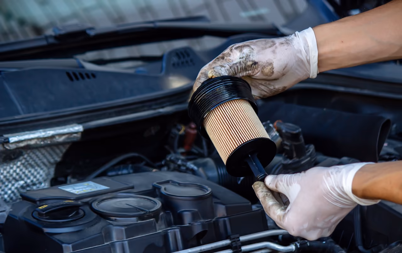Mechanic replacing a car's oil filter during a mobile service