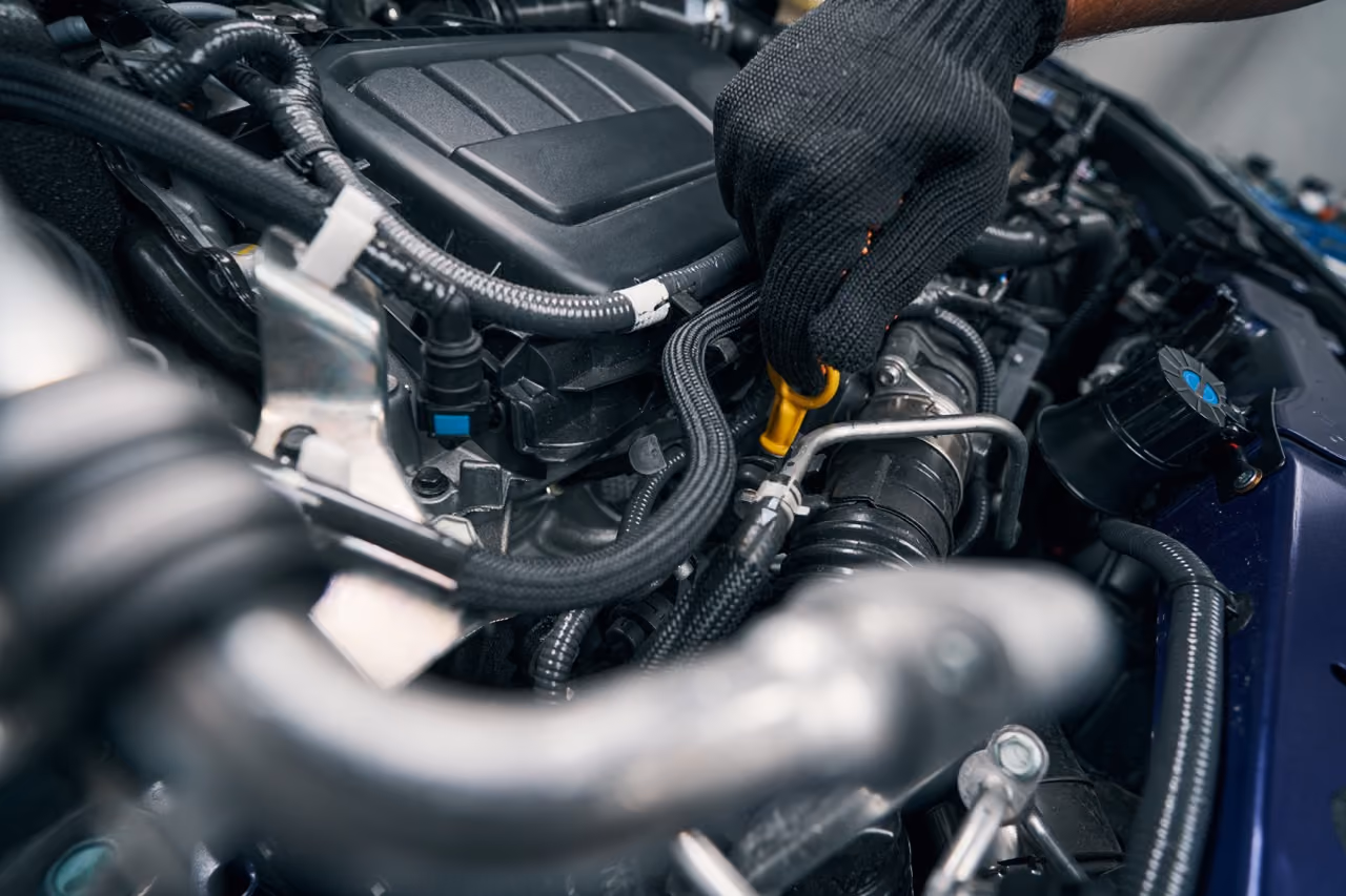 Mechanic working in the engine bay during a mobile interim car service
