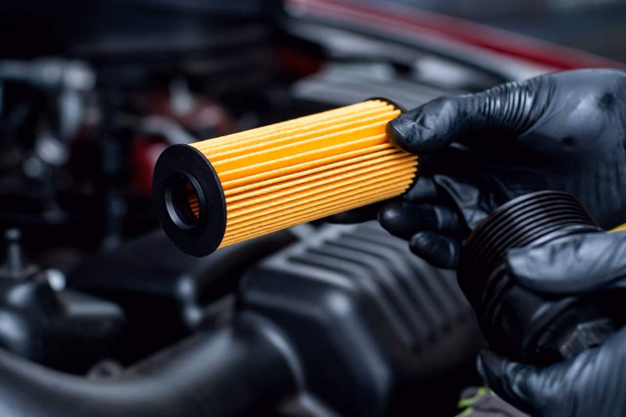 Mechanic holding a new oil filter during a major car service