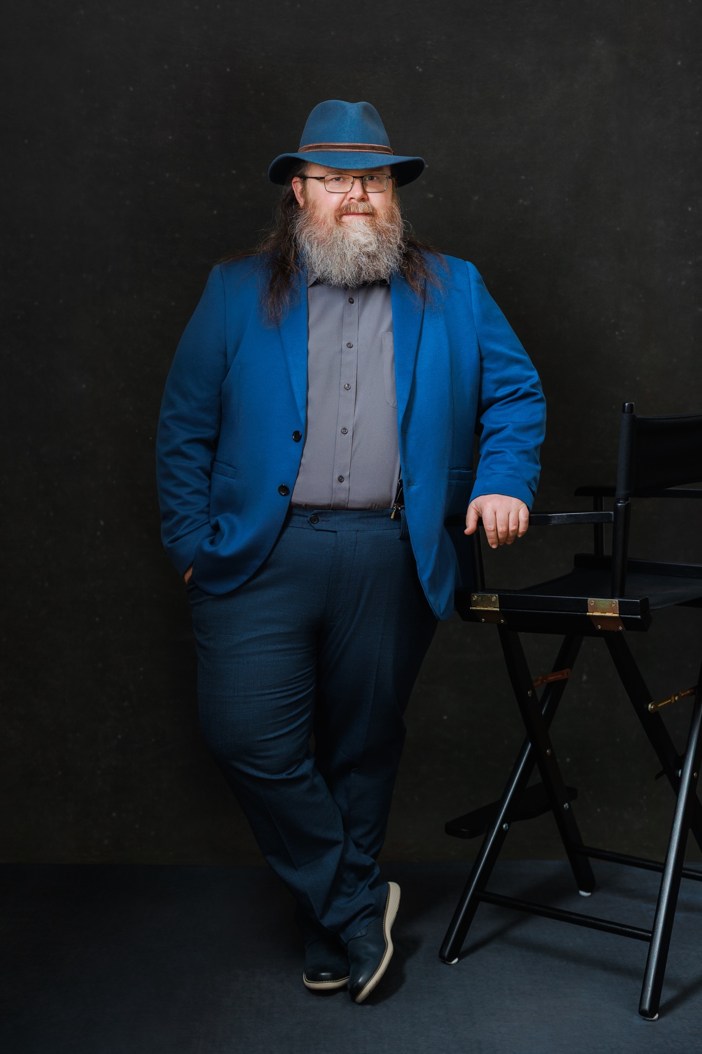 Craig stands casually next to a chair