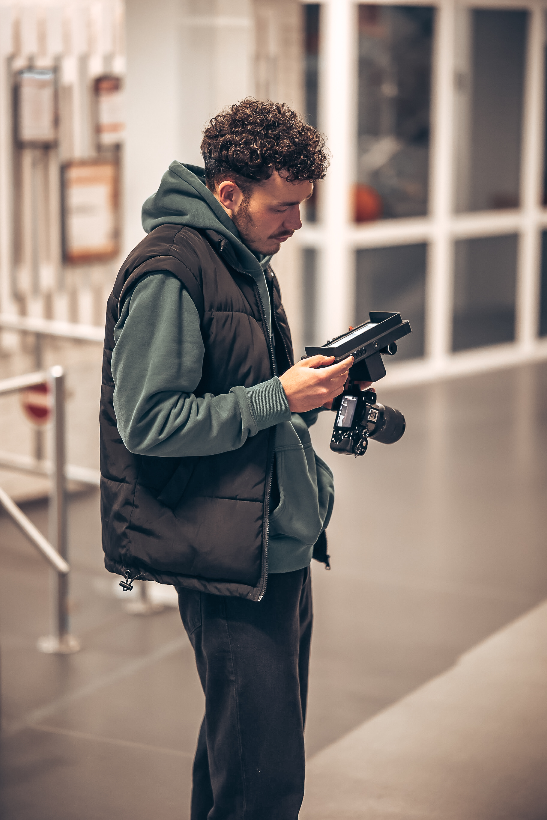 Fotograf prüft Aufnahmen am Kameramonitor in einem hellen Foyer