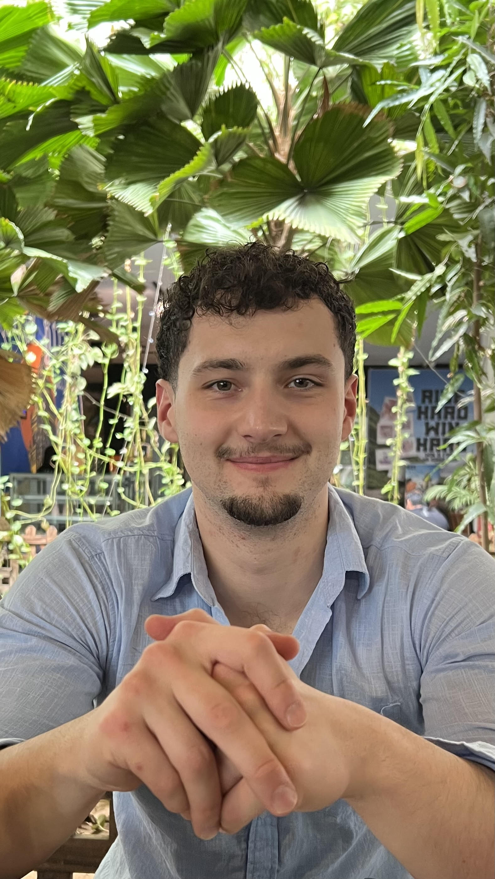 A portrait photo of Harry Wintour, the founder of Whitecross Digital, smiling in front of a forest background.