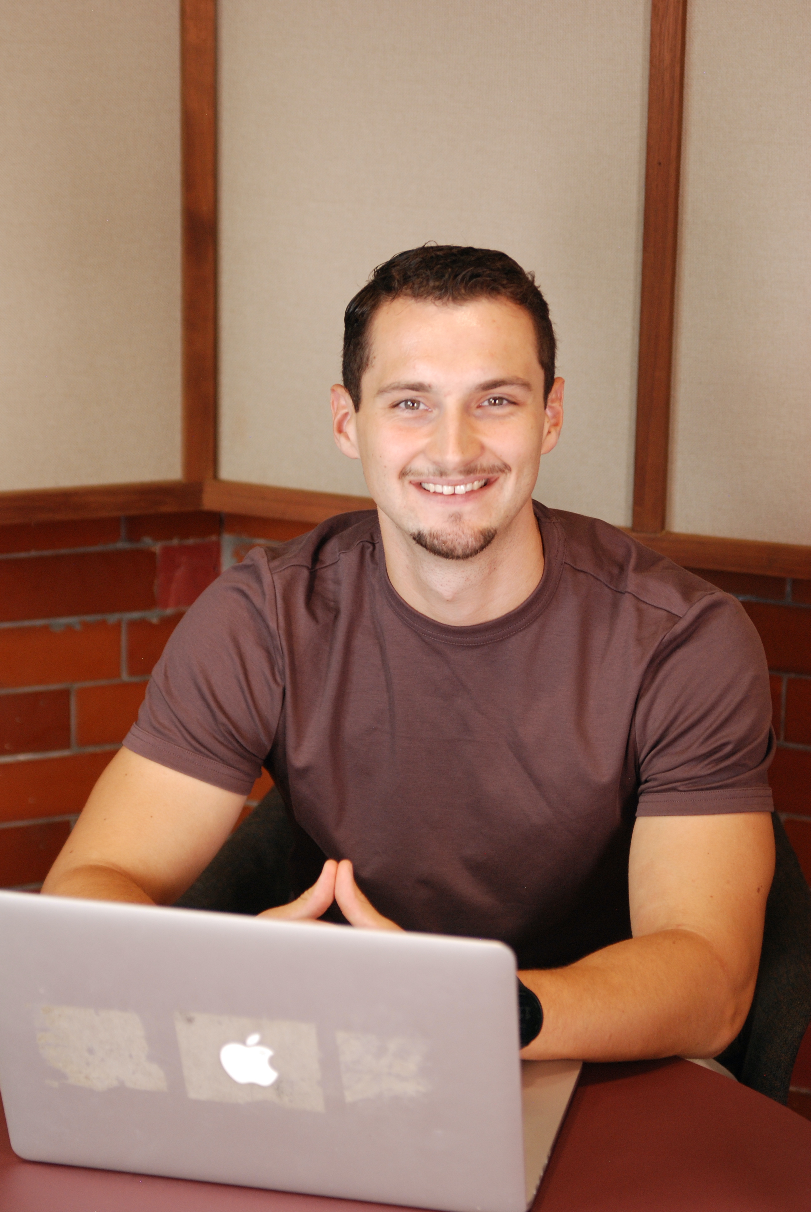 A portrait photo of Harry Wintour, the founder of Whitecross Digital, smiling in front of a forest background.
