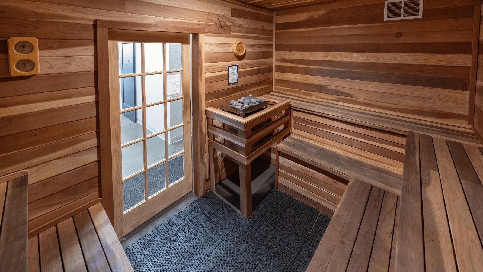 Interior of the cedar dry sauna at Fitsi Escondido, with tiered benches and a heater full of stones.