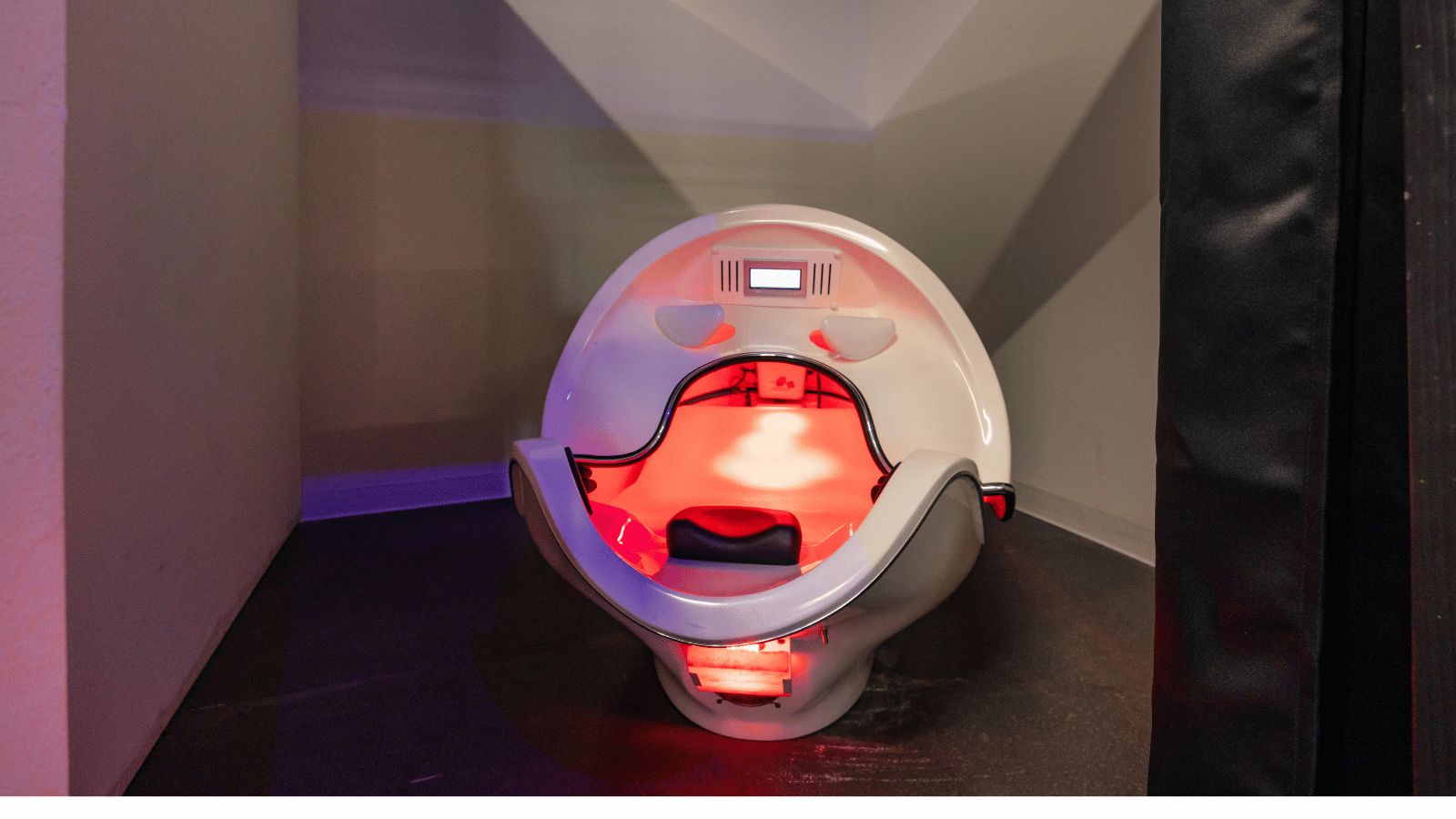 The red light therapy pod at Fitsi Escondido, open and lit from inside.