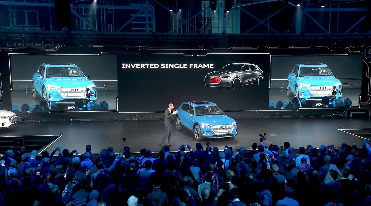 Audi e-tron vehicle presentation with stage screens and audience at the launch event