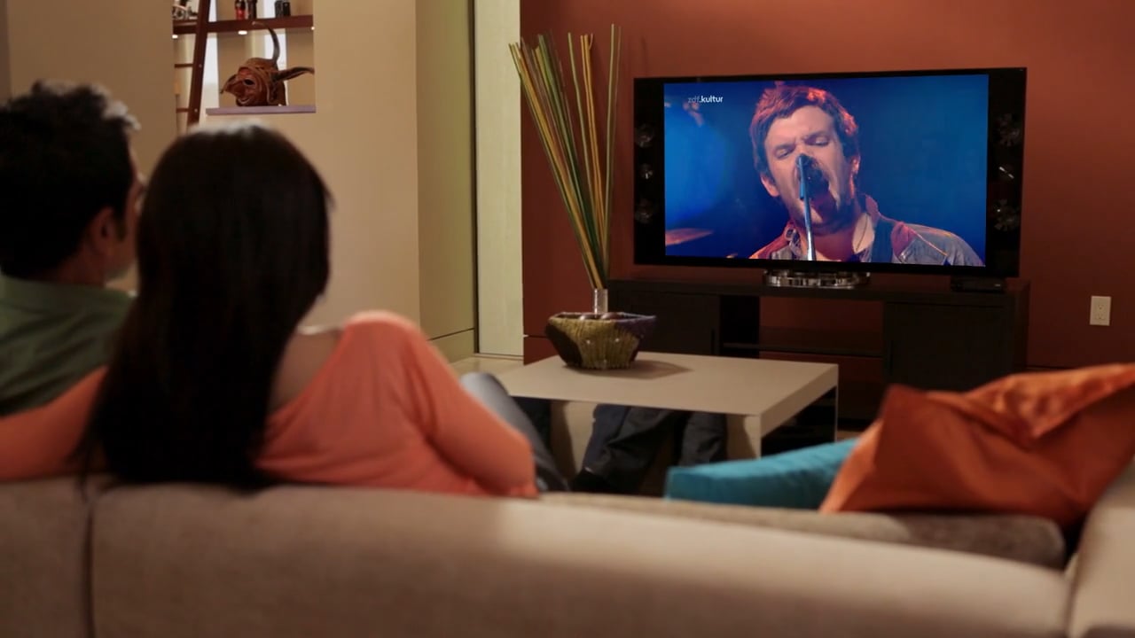 Couple watching television in a living room in OpenTV Product Demo II