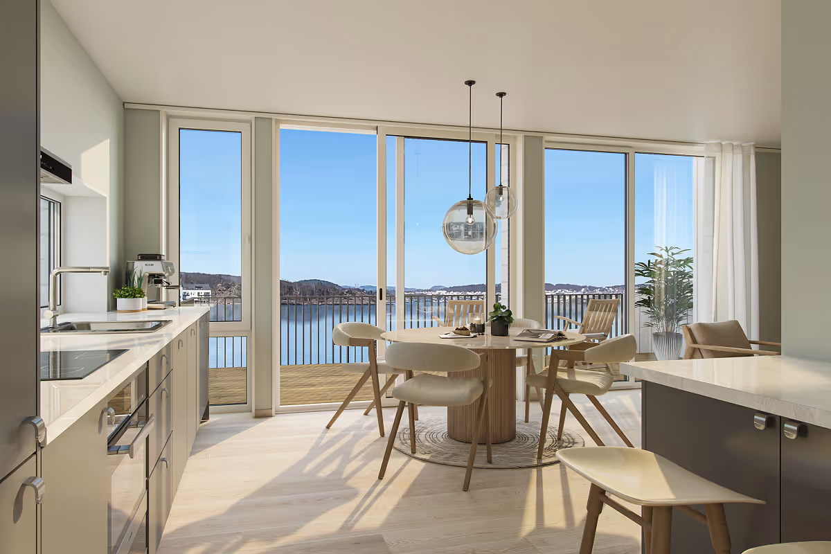 Bright kitchen and dining area with large windows overlooking a balcony and scenic waterfront view.