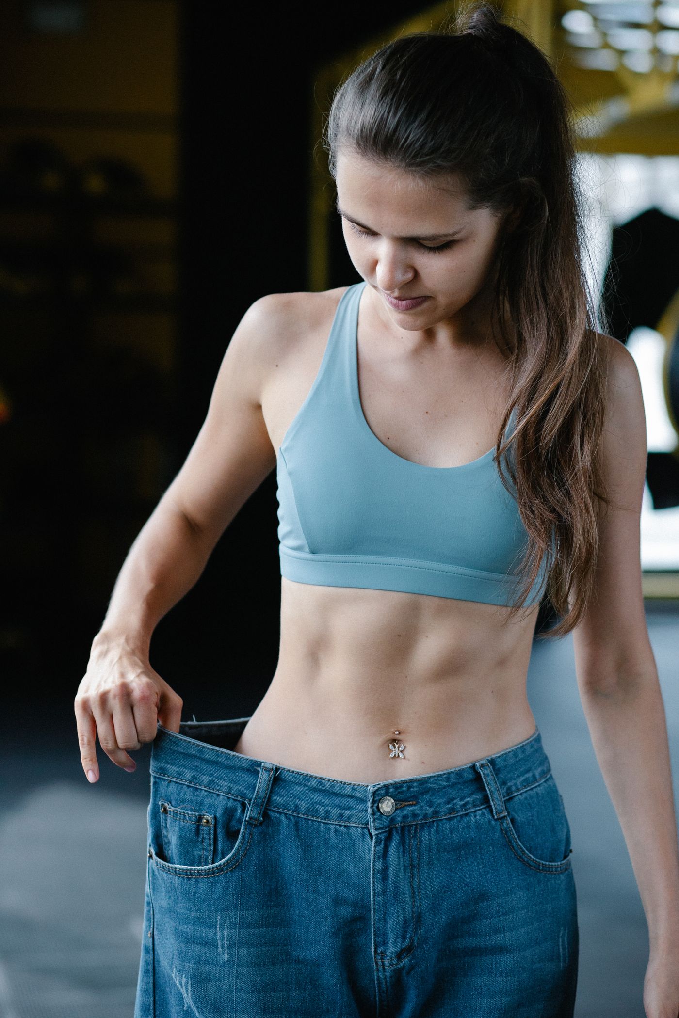 Athletic woman wearing too-large jeans after fat loss