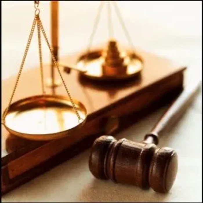Brass scales of justice and a wooden gavel resting on a law book