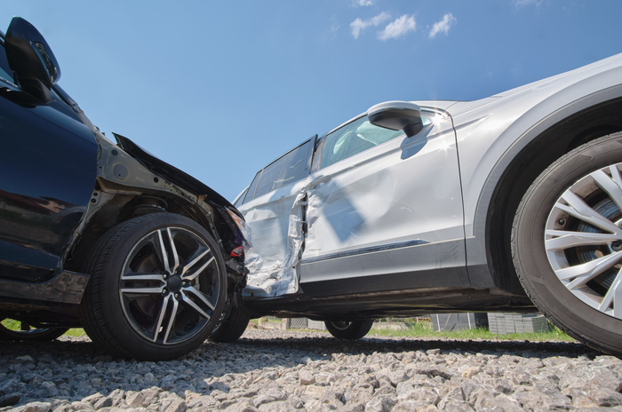 A black car and a white SUV with heavy body damage after a side-impact collision