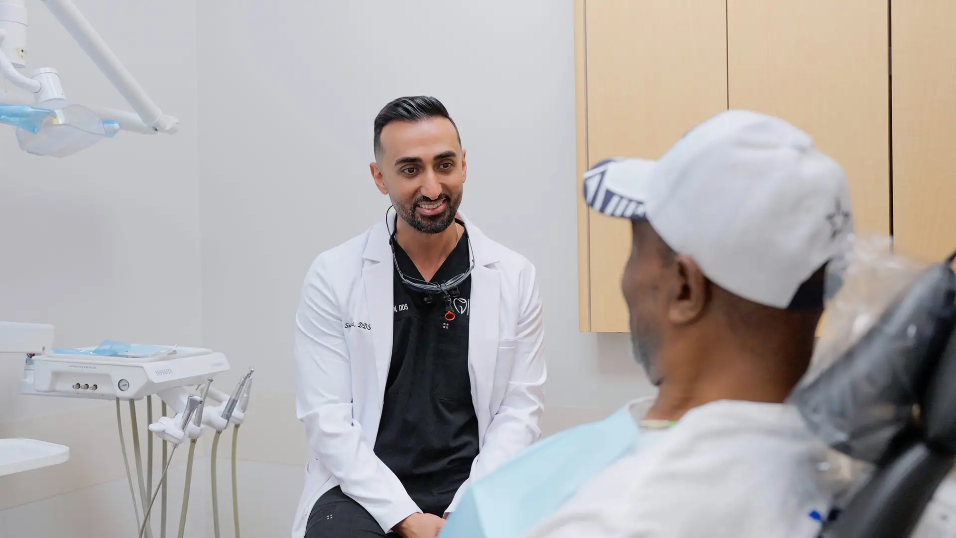 Dr. Sasan Bastani talking with a patient in the treatment room