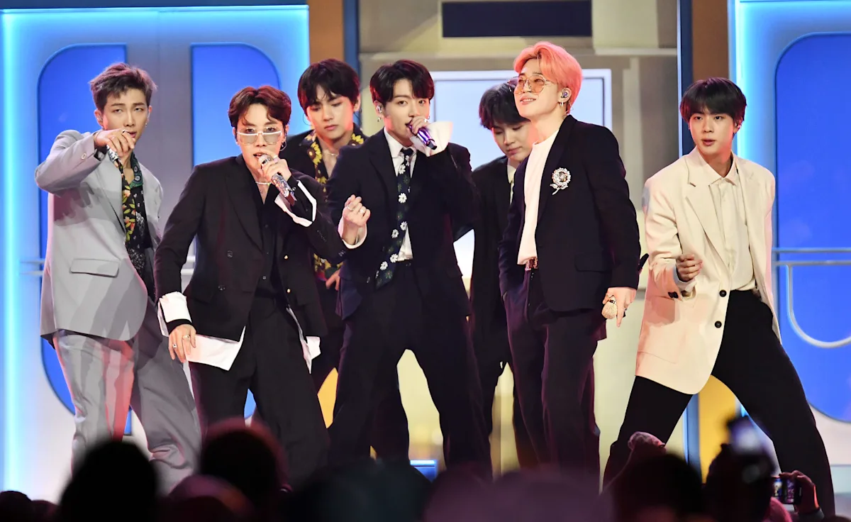 BTS performing live in suits at SoFi Stadium.