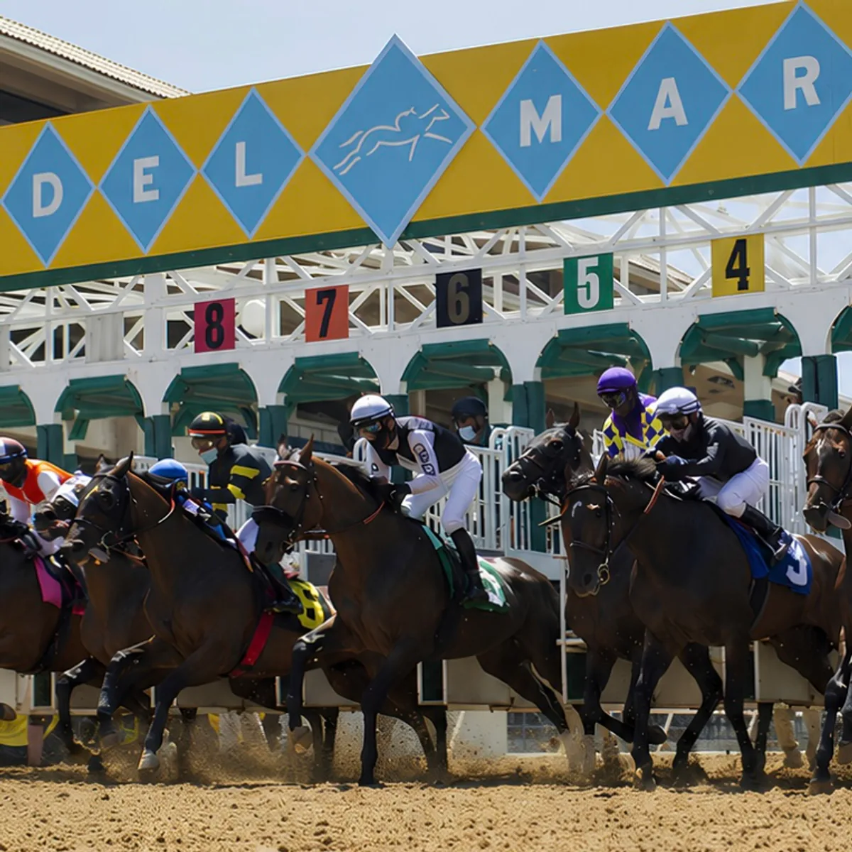 Racehorses break from the starting gate beneath the Del Mar sign