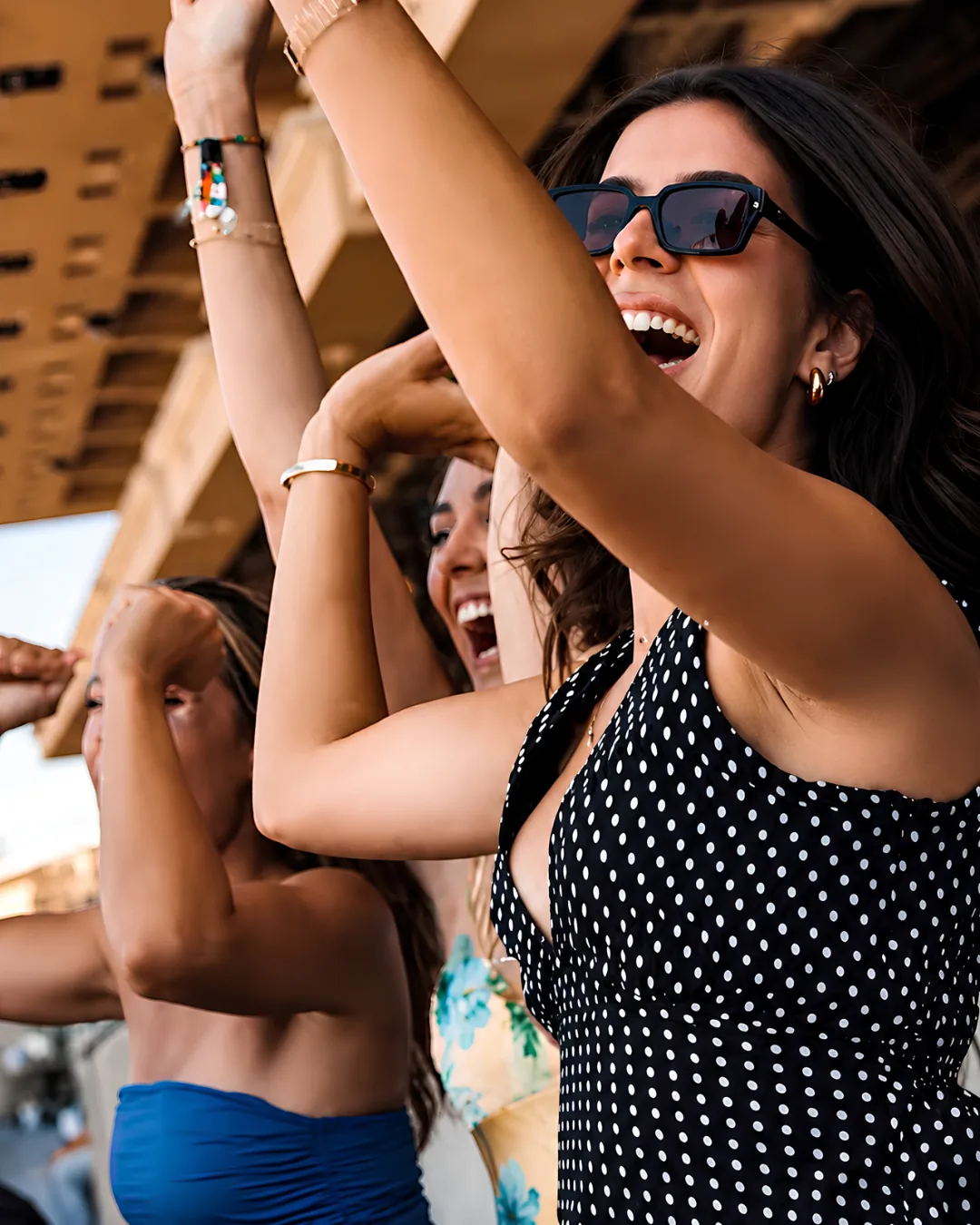 Guests in summer dresses cheering as the field runs at Del Mar