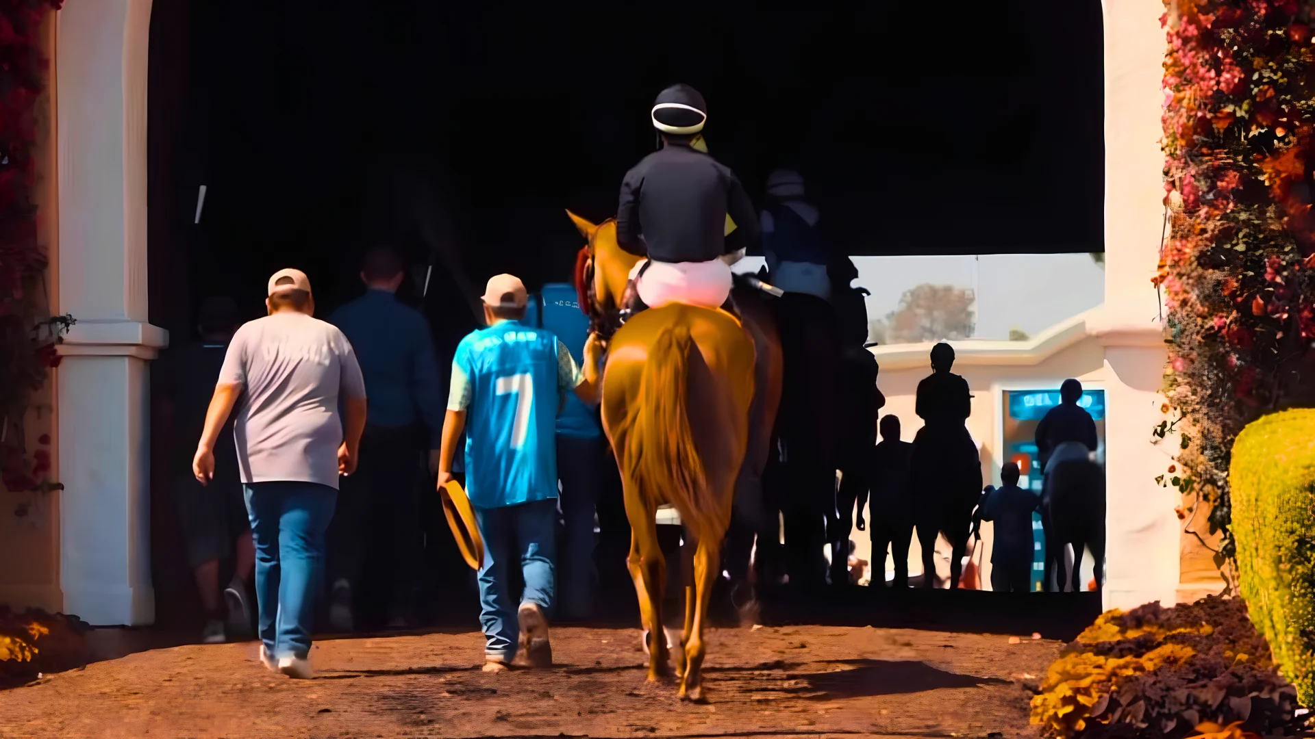 A horse led through the flowered tunnel toward the Del Mar track