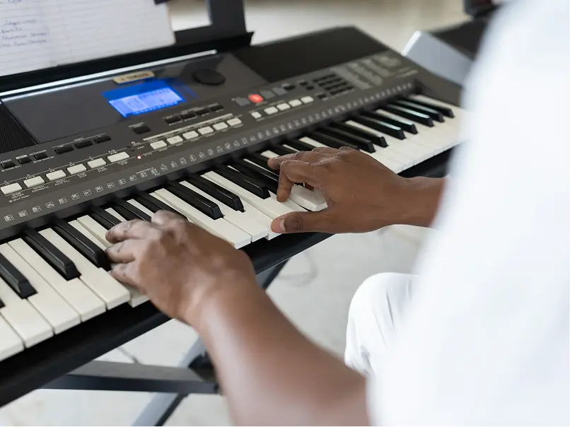 Hands playing an electronic keyboard.