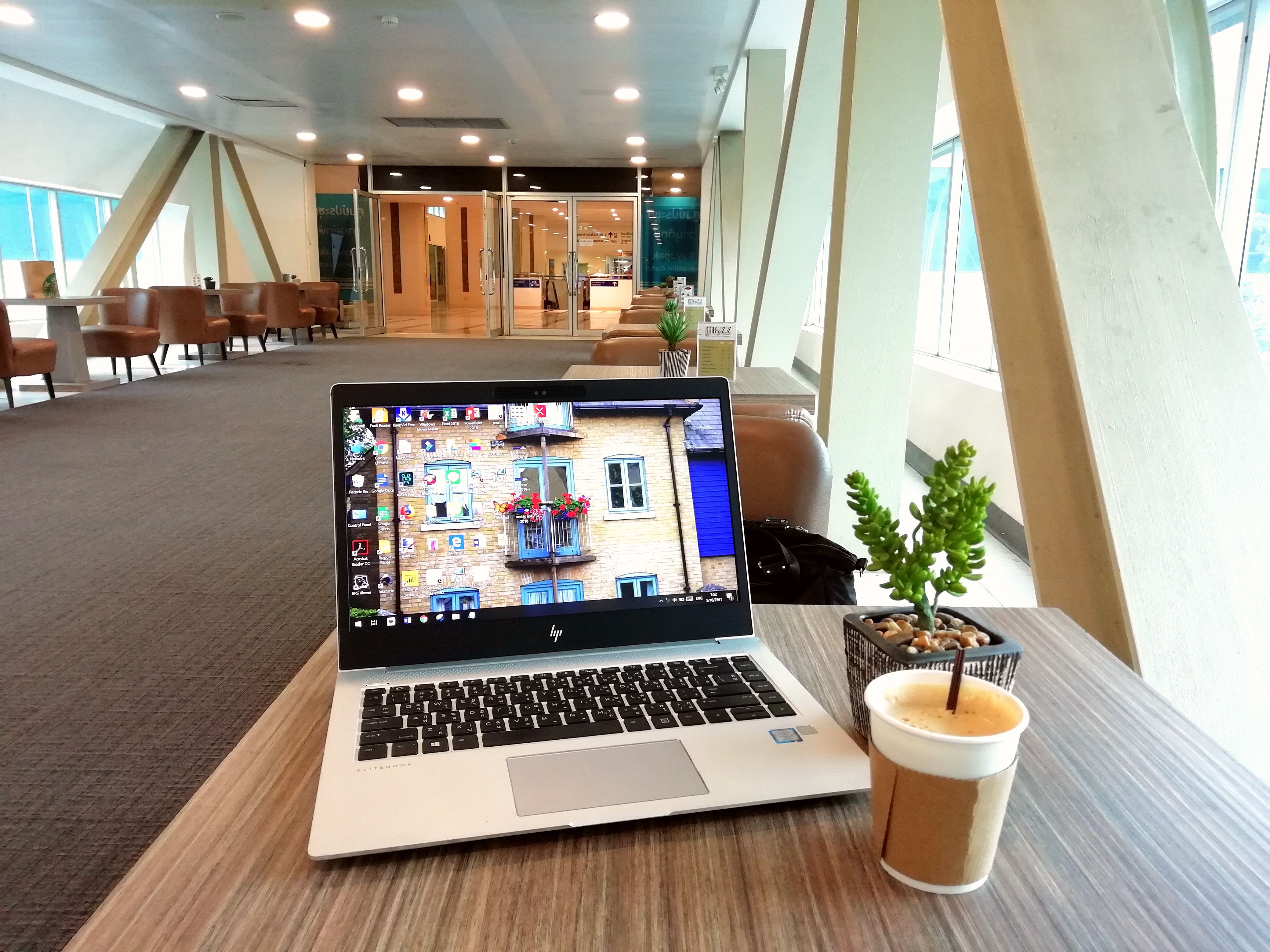 A traveller enjoying a calm coffee during an airport stopover, reflecting on the value of rest and financial peace.