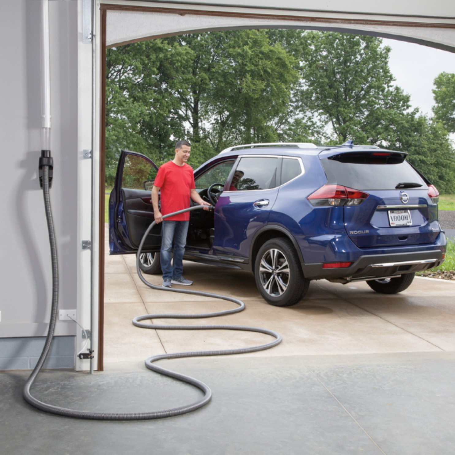 Garage retractable hose cleaning a vehicle