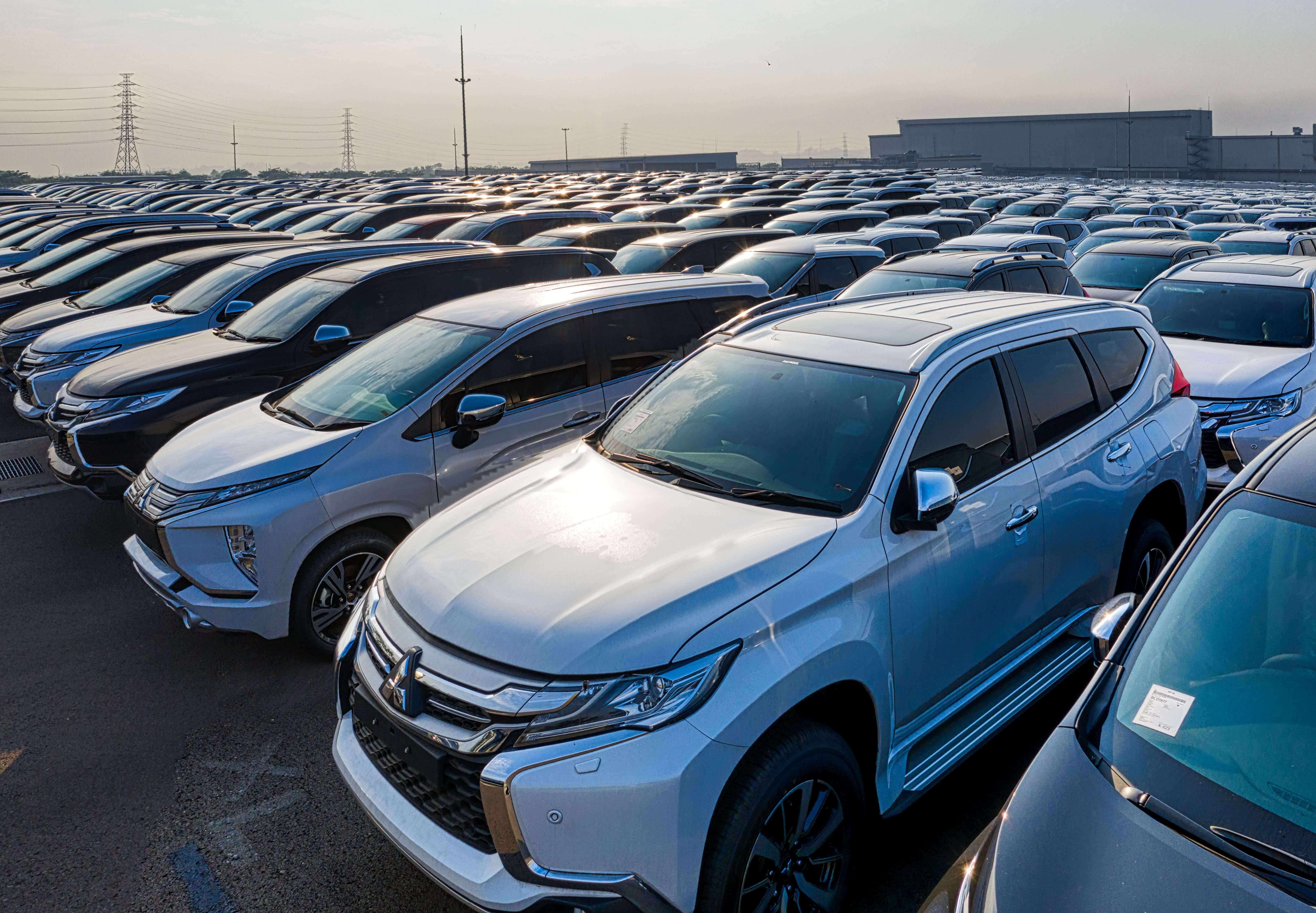 Large lot filled with rows of new Mitsubishi SUVs parked closely under soft daylight.