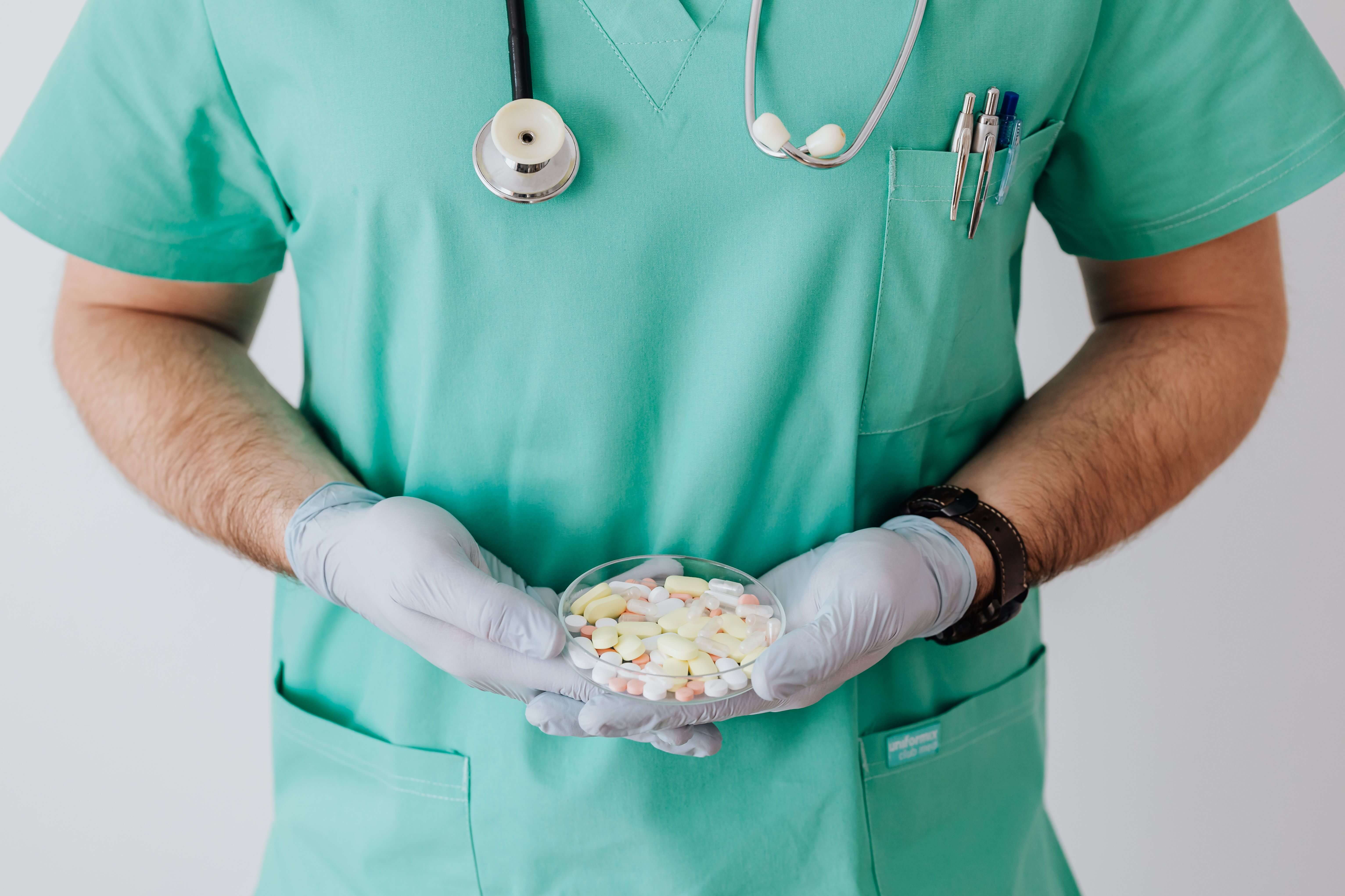 Healthcare professional in green scrubs holding pharmaceutical medication for pharmaceutical cargo logistics