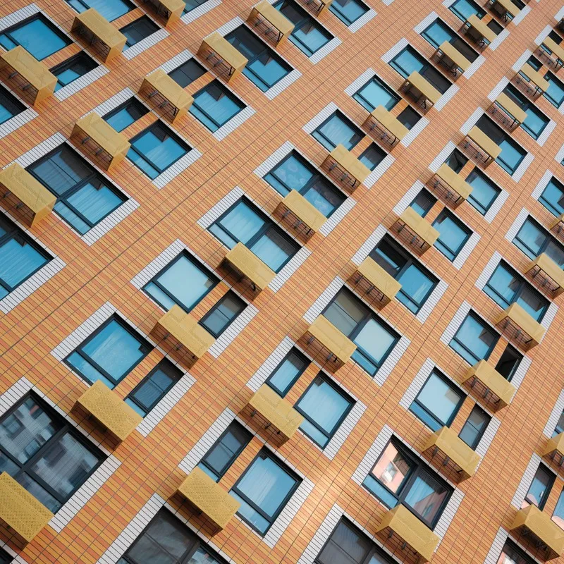 An angled photograph of an orange apartment building.