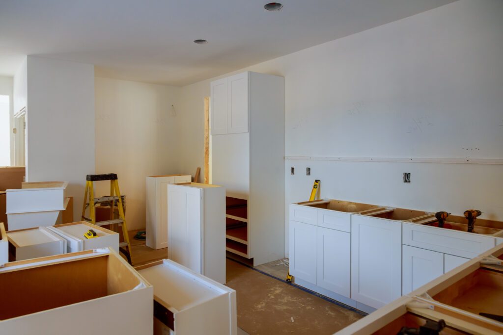 Partially renovated kitchen with new cabinets and unfinished flooring.