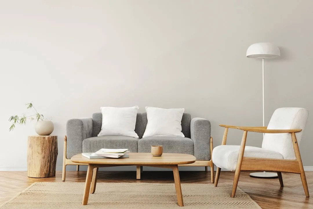 Scandinavian-style living room with grey sofa, white armchair, and wooden coffee table