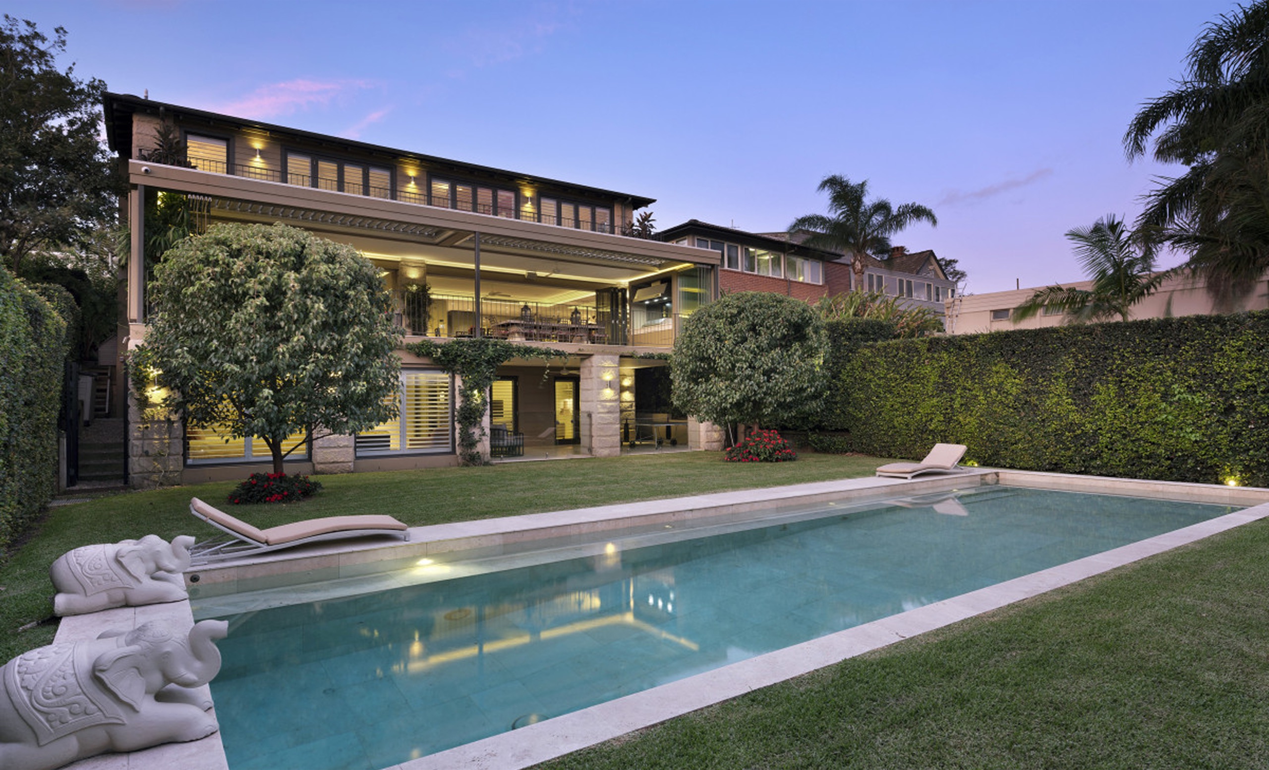 Rear facade and pool at dusk at Clanalpine St, Mosman by Sydneyside Contracting