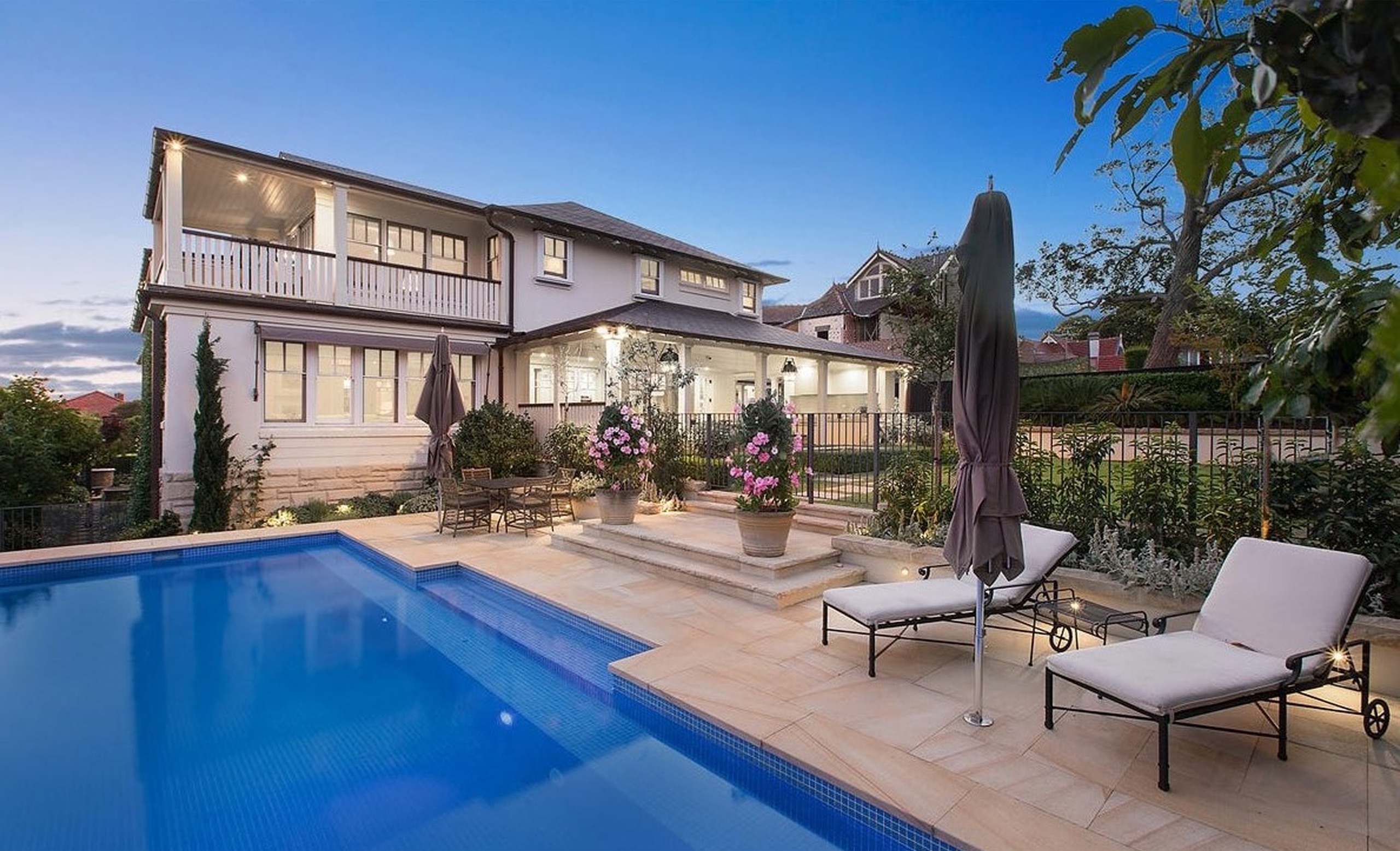 Pool and rear facade at dusk at Thompson St, Mosman by Sydneyside Contracting