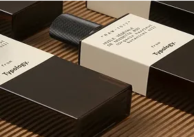Two rectangular Typology product boxes with white labels on a wood surface.