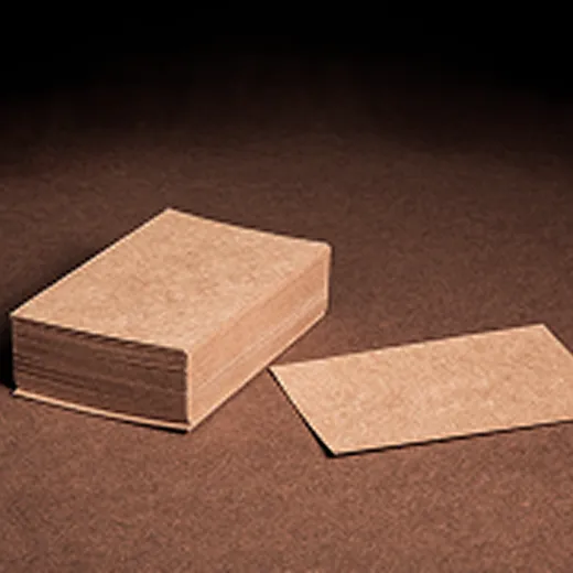 Stack of blank brown business cards on a matching brown surface with one card lying flat.