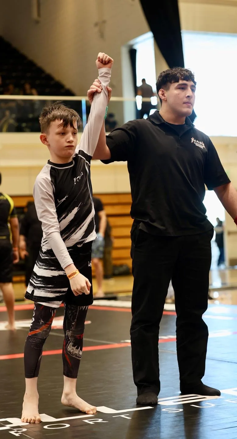 KD MMA coach celebrating a young grappler's win at a tournament