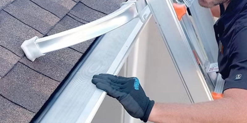 Professional gutters repair contractor in Lambertville, Michigan adding gutter guards to gutters in home