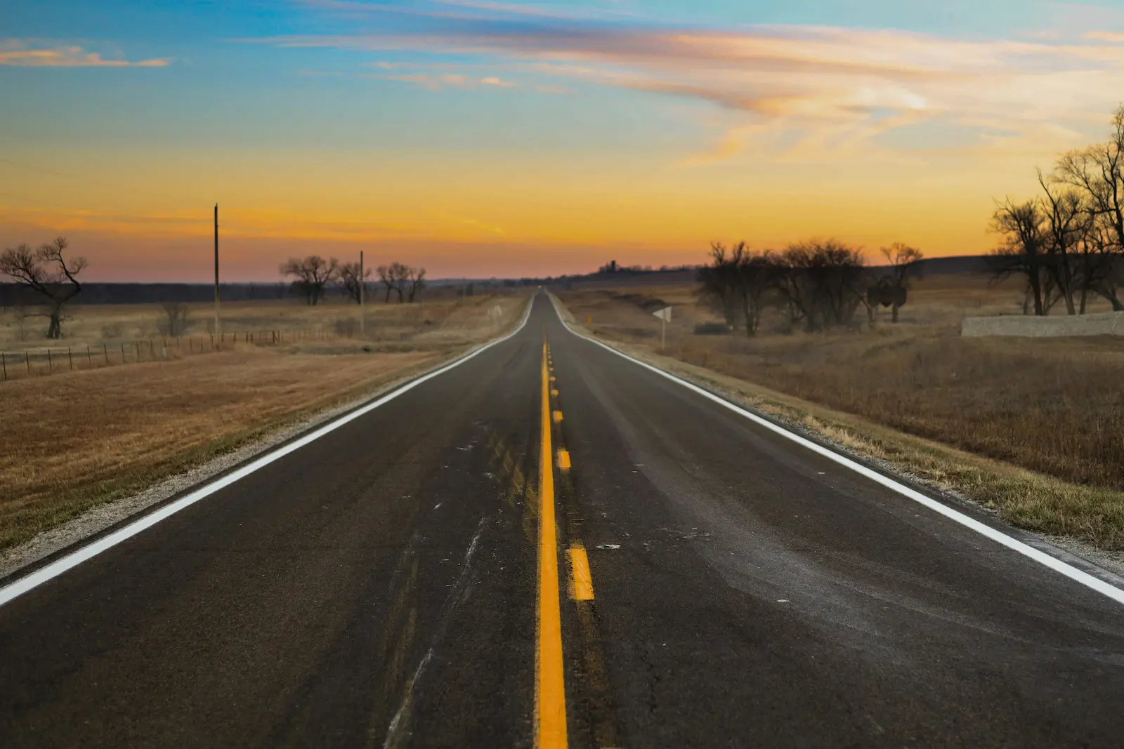 Empty Kansas highway at sunset