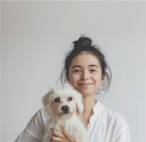 Young woman with small, white dog in their arms