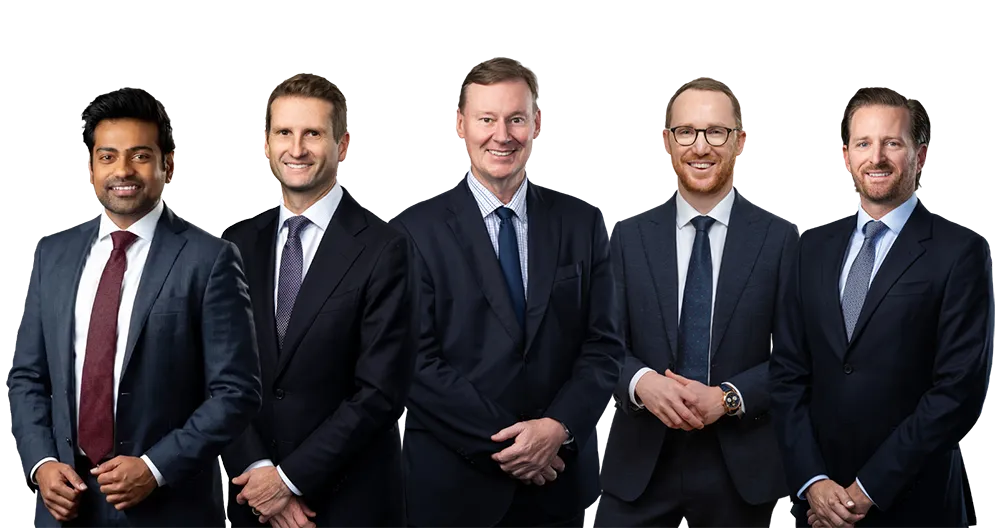 Group of five men in business suits standing side by side, smiling at the camera.