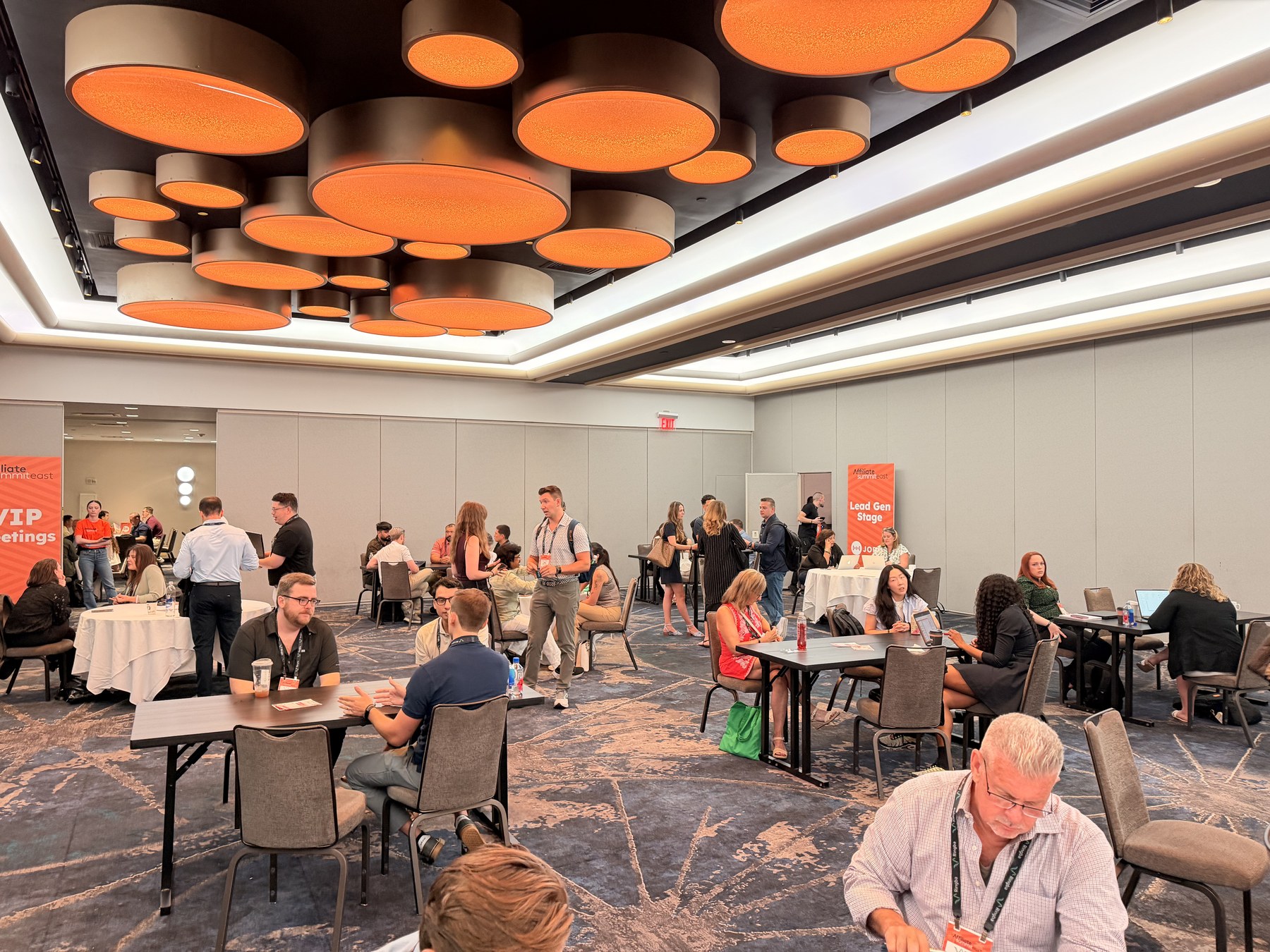 Attendees holding meetings and networking at Affiliate Summit East in New York.