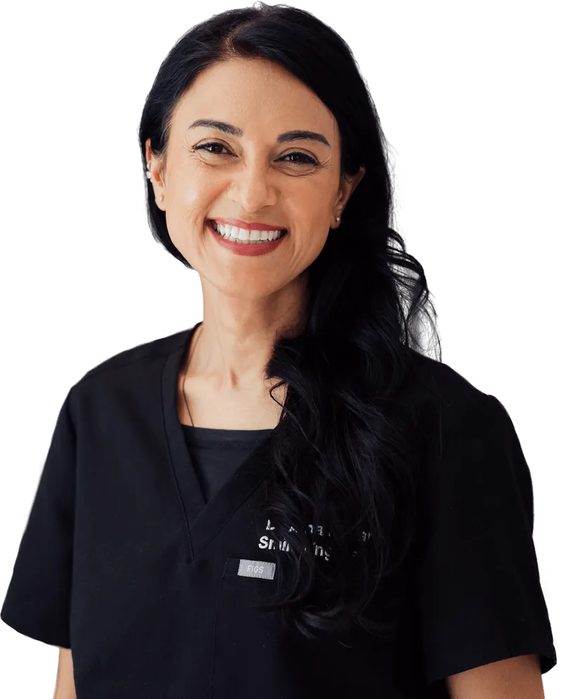 Smiling woman with long black hair wearing black medical scrubs.