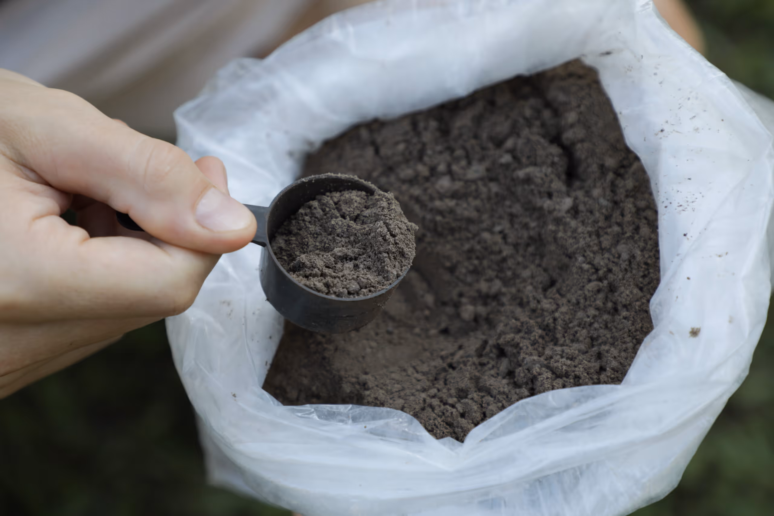 Rock powder being scooped out of a plastic bag