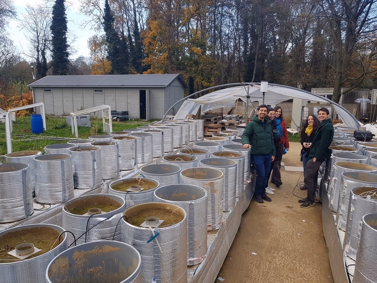 Researchers posing with the University of Antwerp’s mesocosm experiments, which is part of their Research on Enhanced Weathering
