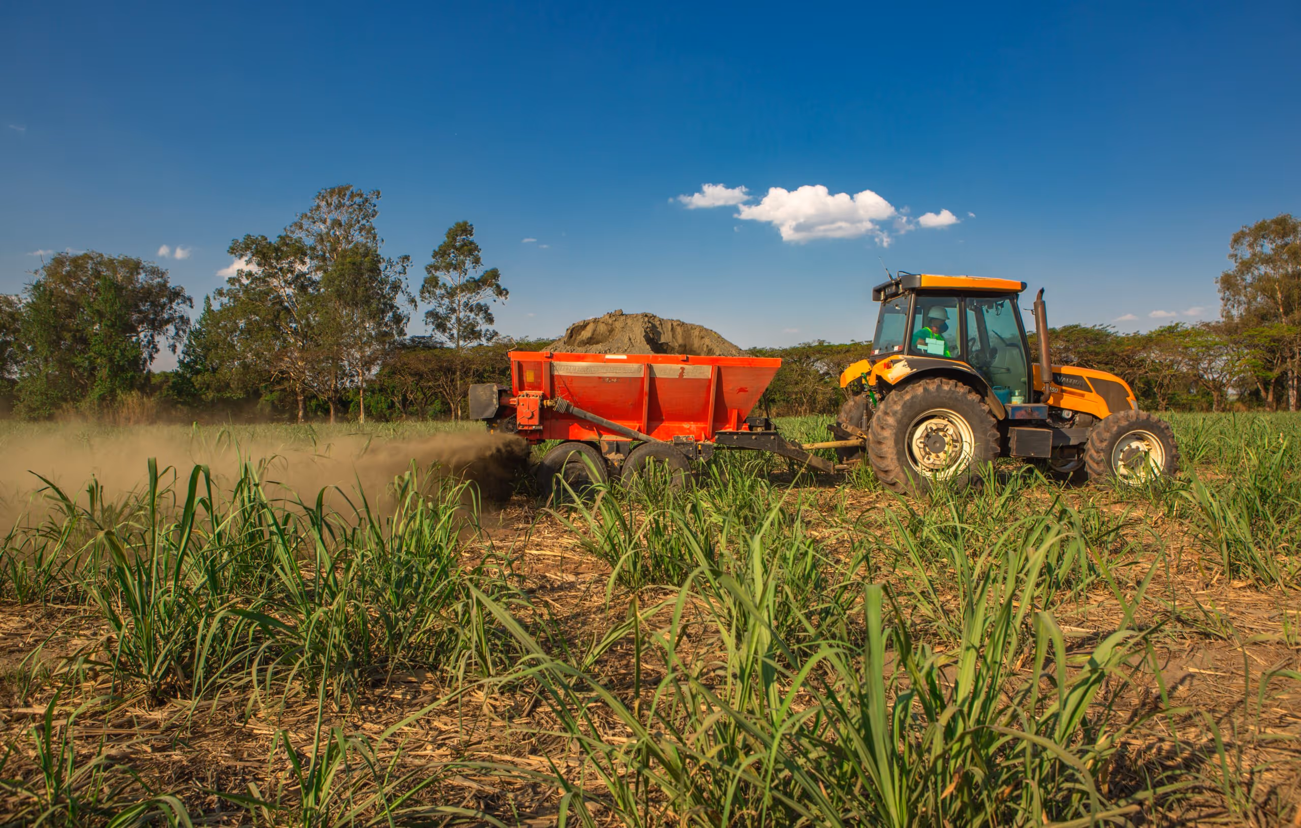 tractor spreading rock powder on a green field