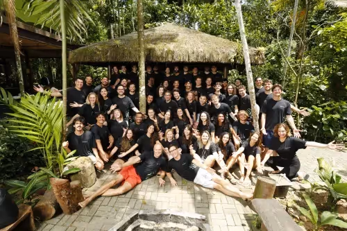 InPlanet team members gathered for a group photo at a rainforest retreat in Brazil, surrounded by tropical vegetation.