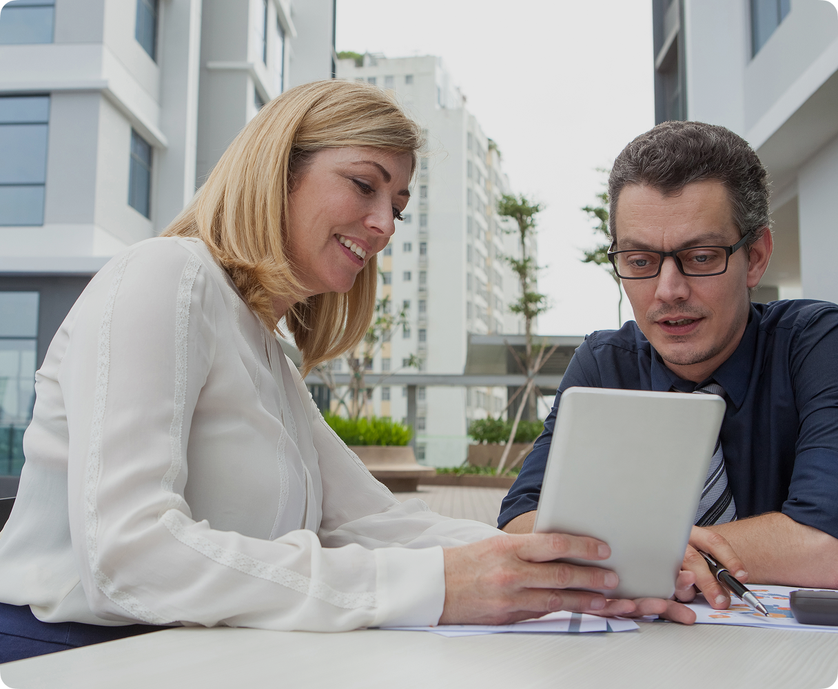 A woman showing a man a guide on a tablet