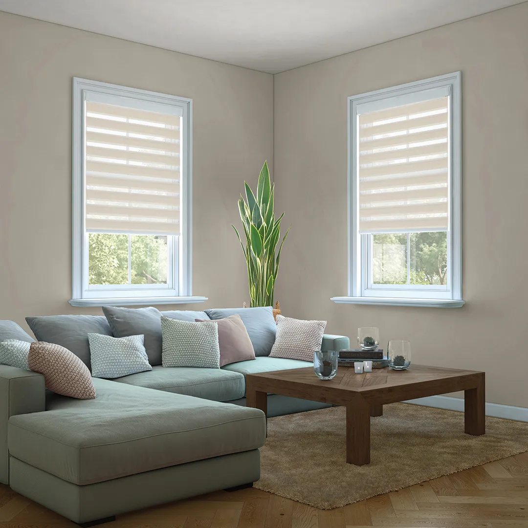 Modern living room with sectional sofa, wooden coffee table, beige walls, and two windows with striped blinds.